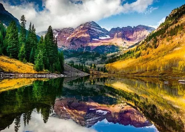 ravensburger jigsaw puzzle image of Mountain landscape with a lake reflecting the mountains and trees.