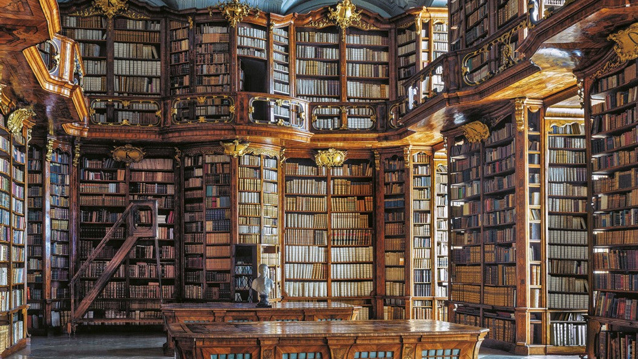 Decorative image of an ornate library interior with tall bookshelves and warm lighting used as a background on the Piatnik puzzles page.