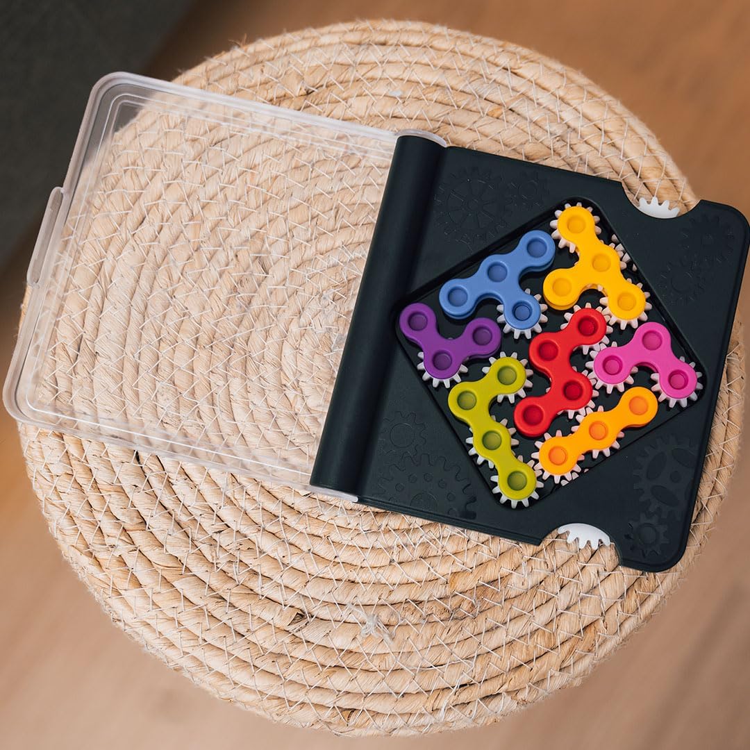 Colorful gear-shaped puzzle pieces in a black carrying case on a woven surface
