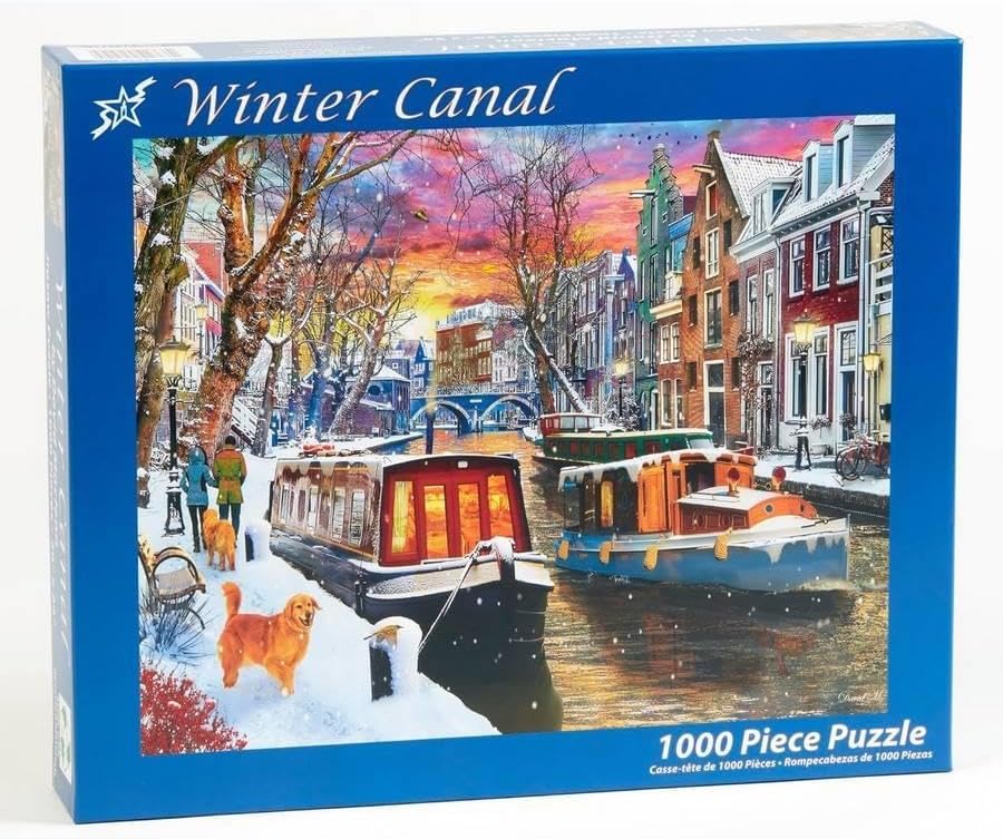 vermont christmas company 1000-piece Jigsaw puzzle box featuring a winter canal scene with houses and boats.