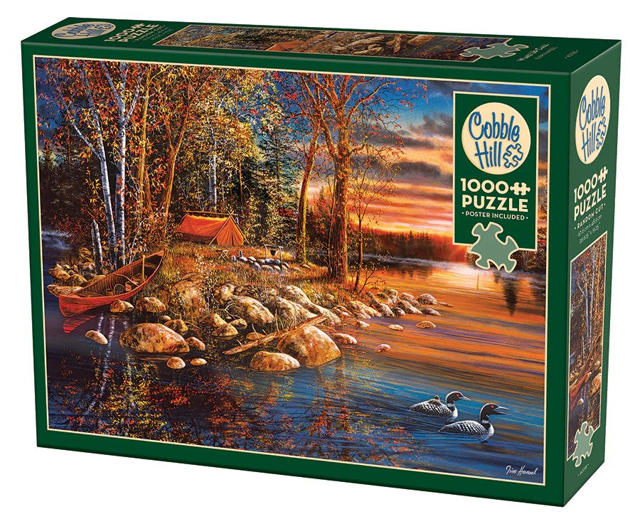 Jigsaw puzzle box featuring a scenic lake with trees and a tent, brand 'Cobble Hill' visible.