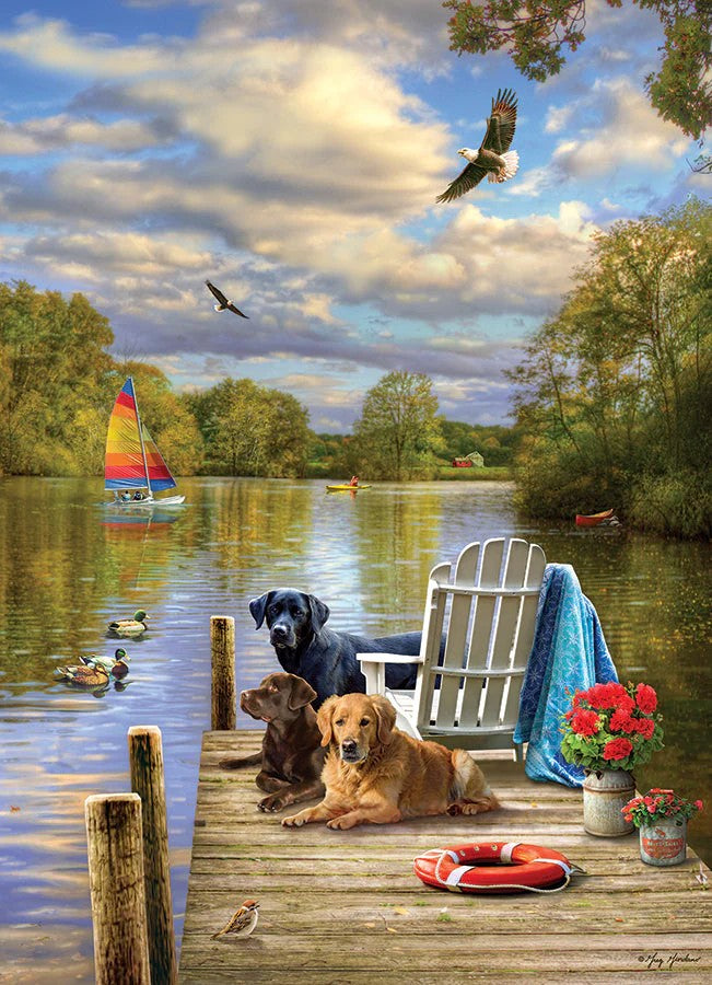 Cobble Hill jigsaw puzzle of Two dogs on a dock by a lake with a sailboat and trees in the background.