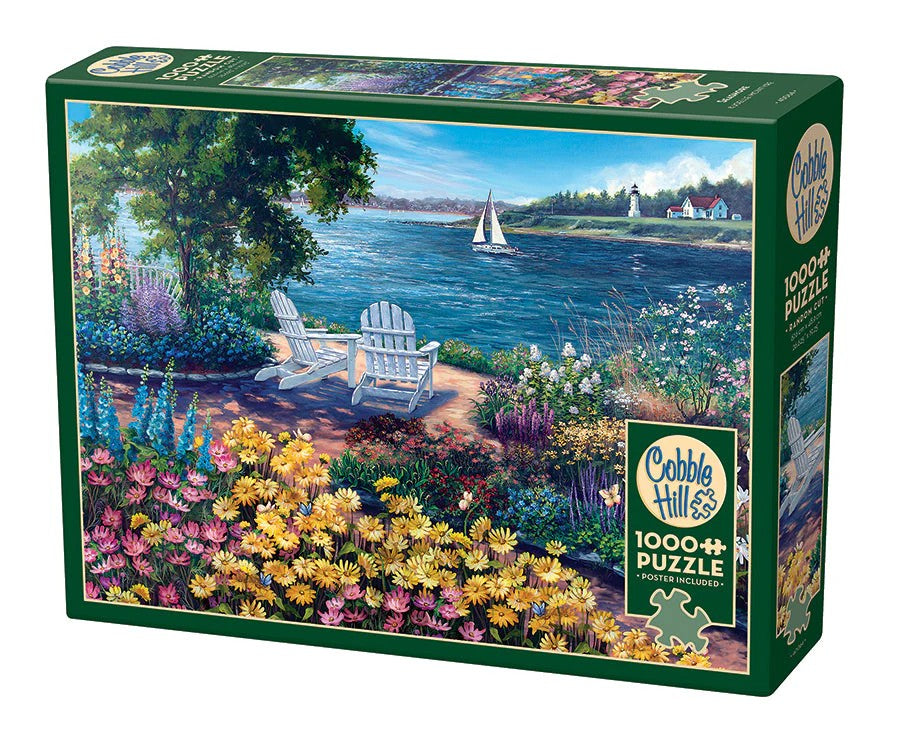 Cobble Hill 1000-piece jigsaw puzzle box of a seaside view with flowers, chairs, and lake.