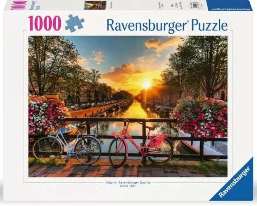 1000-piece Ravensburger jigsaw puzzle box of "bicycles in Amsterdam" featuring a scenic canal with bicycles and flowers at sunset.