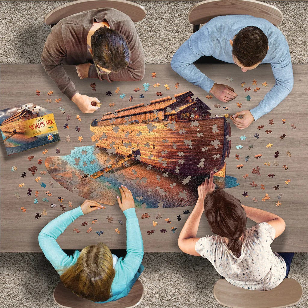 Four people working on a madd capp jigsaw puzzle of Noah's Ark at a table.