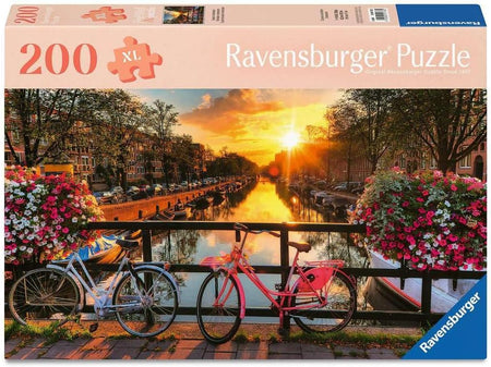 Ravensburger puzzle box with bicycles and flowers on a bridge over a canal at sunset.