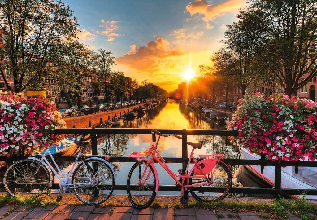 ravensburger sunset in amsterdam jigsaw puzzle of canal scene at sunset with bicycles and flowers in the foreground.